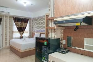 a hotel room with a bed and a pay phone at Minimalist and Comfort Studio Podomoro City Deli Medan Apartment By Travelio in Medan +9 photos