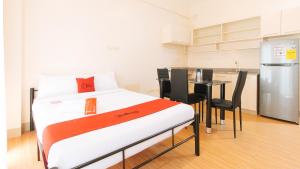 a bed in a room with a table and a kitchen at RedDoorz Plus at Alpina Heights Paranaque in Manila