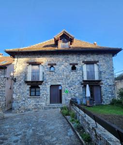 una casa de piedra con porche y tejado en Casa Tadeguaz, en Fago
