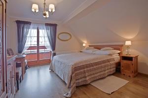 une chambre avec un lit et une grande fenêtre dans l'établissement Willa Grandeus, à Bukowina Tatrzańska