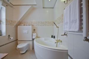 une salle de bains blanche avec toilettes et lavabo dans l'établissement Willa Grandeus, à Bukowina Tatrzańska 71 autres photos