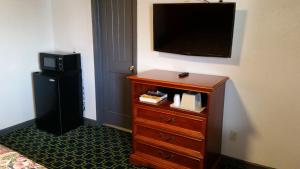 a bedroom with a dresser with a television on a wall at Budget Inn El Reno in El Reno