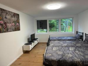 a bedroom with two beds and a television in it at Monteurwohnung Koeln- Rösrath in Rösrath