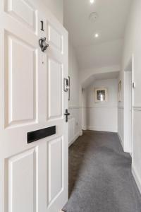 a white door in a room with a hallway at Elegant Malvhina Retreat on the Malvern Hills in Great Malvern