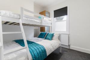 a bedroom with two bunk beds with blue pillows at Elegant Malvhina Retreat on the Malvern Hills in Great Malvern
