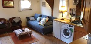 a living room with a couch and a washing machine at Treppenspeicher Killmann in Bispingen