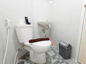 un baño con inodoro y lavabo en Modern Look and Homey Studio Amartha View Apartment By Travelio, en Semarang