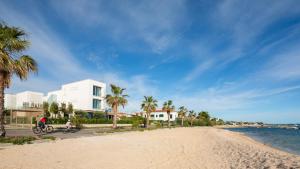 two people riding bikes on a beach with palm trees at Villa Piano Turanj - Adriatic Luxury Villas in Turanj