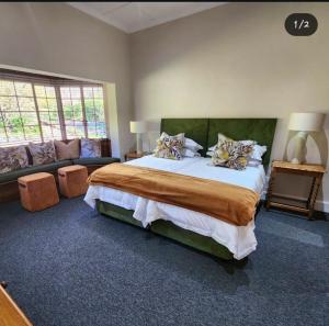 a bedroom with a large bed and a couch at Hydrangea Guest House in Nottingham Road +61 photos