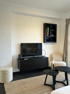 Una sala de estar con un televisor de pantalla plana en una pared. en Appartement aan het strand, en Cartagena