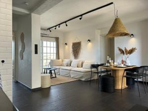 Una sala de estar con un sofá blanco y una mesa. en Appartement aan het strand, en Cartagena
