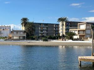 una playa con palmeras y edificios de fondo en Appartement aan het strand, en Cartagena
