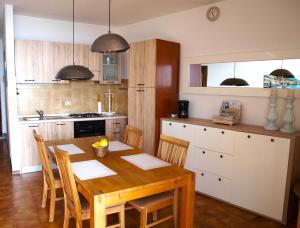 a kitchen with a wooden table and chairs in a kitchen at Il Patio - Theater Home in Tignale +12 photos