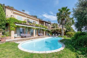a house with a swimming pool in the yard at Villa de vacances 5 chambres piscine privée et vue mer panoramique in Mandelieu-la-Napoule
