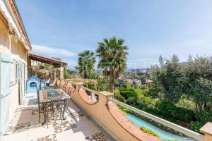 an outdoor balcony with a slide and a pool at Villa de vacances 5 chambres piscine privée et vue mer panoramique in Mandelieu-la-Napoule