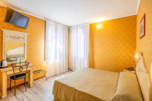 Ένα ή περισσότερα κρεβάτια σε δωμάτιο στο Hotel Tintoretto