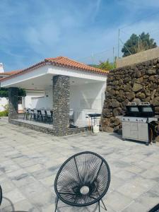 a patio with a grill and a stone wall at Villa SOHLARA in La Orotava +57 photos