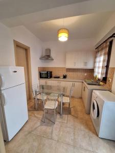 a kitchen with a table and a white refrigerator at D and D Home Alonissos in Alonnisos Old Town