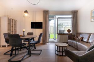 a living room with a couch and a table at Hello Zeeland - Apartment Noordstraat 30 in Zoutelande