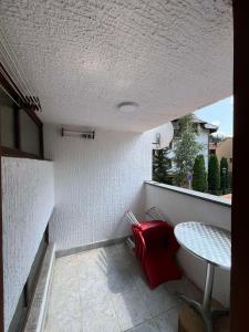 a small balcony with a table and a red pillow at Medo in Zlatibor