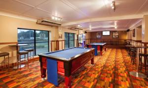 a billiard room with two pool tables and a bar at Nightcap At Balaclava Hotel in Cairns