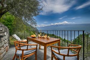 un tavolo e due sedie su un balcone con vista di Piccolo Rustico, Casaliva - Theater Home a Gargnano