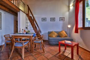 un soggiorno con tavolo, sedie e divano di Piccolo Rustico, Casaliva - Theater Home a Gargnano Altre 4 foto