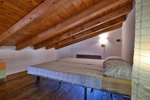 una camera da letto con un letto in una stanza con soffitti in legno di Piccolo Rustico, Casaliva - Theater Home a Gargnano