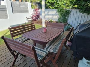 a wooden table and chairs on a deck at Bar Beach Retreat in Newcastle