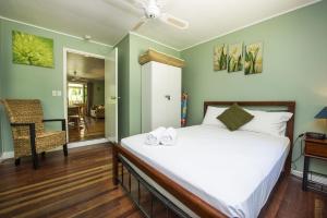 a bedroom with a large white bed and a chair at OurBonnieDoon in Arcadia