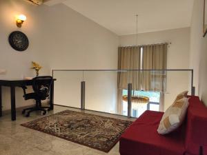 - un salon avec un canapé rouge et un bureau dans l'établissement Hostie Evanya - 2BHK Serviced Apartment near Golf Course Road, à Gurgaon