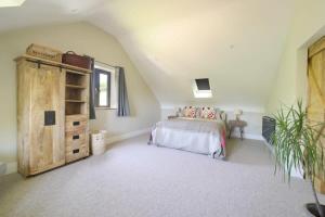 a bedroom with a bed and a wooden cabinet at Contemporary Cottage & Garden in Dorset in Blandford Forum