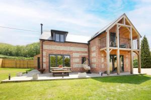 a brick house with a conservatory on a lawn at Contemporary Cottage & Garden in Dorset in Blandford Forum