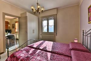 sypialnia z łóżkiem z fioletową kołdrą w obiekcie Villa Margherita - Theater Home w mieście Tignale