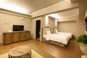 a bedroom with a bed and a flat screen tv at Chihpen Hotel Royal Kingdom in Wenquan