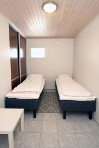 two beds in a small room with a table at Villa Vallaton 3 Bedroom Apartment in Jämsä