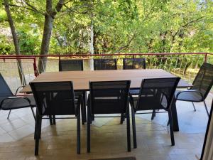 a wooden table and chairs on a balcony with trees at Apartments with parking space Moscenicka Draga, Opatija - 2346 in Mošćenička Draga