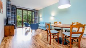 salon ze stołem, krzesłami i kanapą w obiekcie Hapimag Apartments Cannero w mieście Cannero Riviera