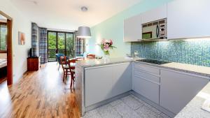 kuchnia i jadalnia z białymi szafkami i stołem w obiekcie Hapimag Apartments Cannero w mieście Cannero Riviera