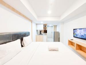 TV a/nebo společenská místnost v ubytování Cozy and Strategic Studio Apartment at De Prima By Travelio