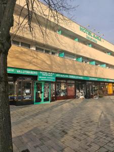 budynek z sklepami przed nim w obiekcie Hotel Ajka Üzletház Panzió Ajka w mieście Ajka