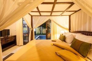 a bedroom with a large yellow bed with a window at 6-BR Private Pool Legian Villa 5-min Walking to Beach in Seminyak