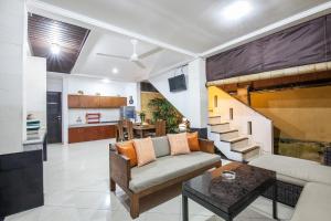 a living room with a couch and a staircase at 6-BR Private Pool Legian Villa 5-min Walking to Beach in Seminyak