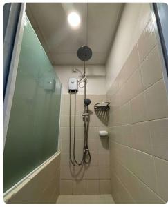 a shower with a shower head in a bathroom at Tagaytay Prime Residence City Land in Tagaytay +9 photos