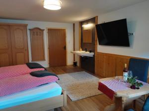 ein Schlafzimmer mit Bett und Flachbildfernseher in der Unterkunft Ferienhaus Carmen in Grän