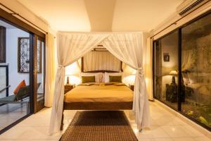 a bedroom with a bed with a canopy at 6-BR Private Pool Legian Villa 5-min Walking to Beach in Seminyak +24 photos