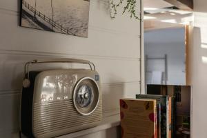 ein altes Radio auf einem Regal neben Büchern in der Unterkunft Workers cottage on Wellington in Hobart