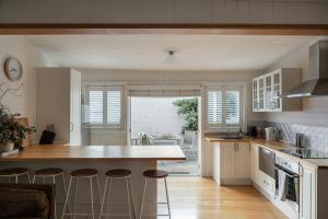 eine Küche mit einer Theke und Hockern darin in der Unterkunft Workers cottage on Wellington in Hobart