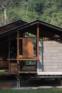 un pequeño edificio con un porche encima en Mon Ing Suk Eco-Stay Chiang mai, en Chiang Mai