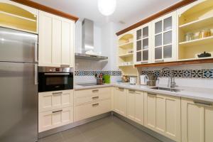 a kitchen with white cabinets and a stainless steel refrigerator at Veoapartment Zaragoza in Seville +17 photos